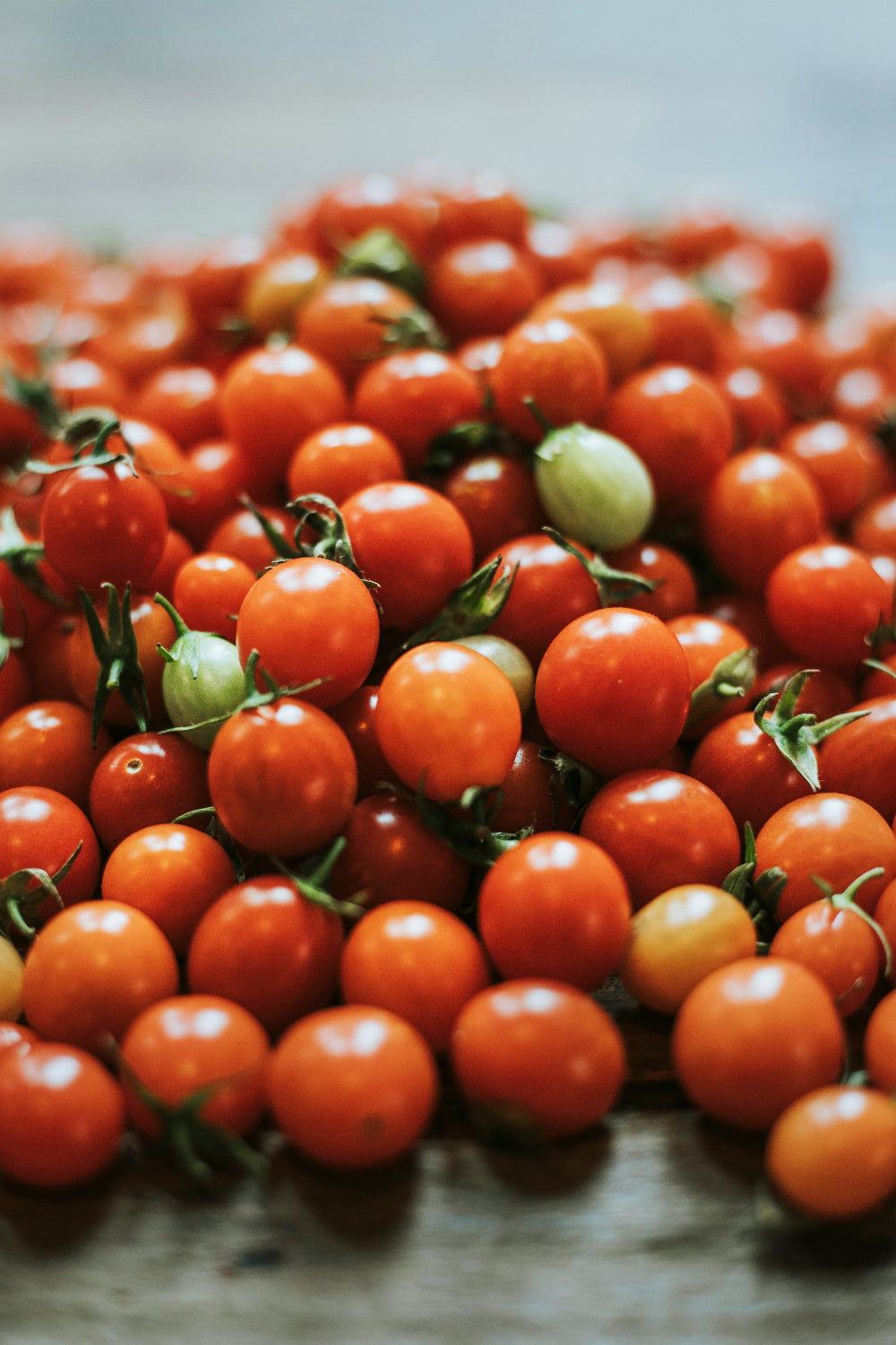 Close-up of a pile of cherry tomatoes on a wooden surface